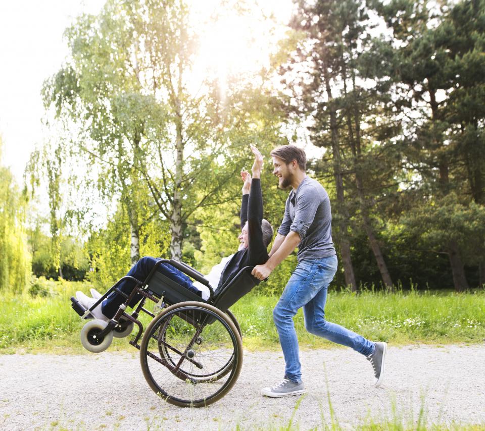 caregiver wheeling a senior